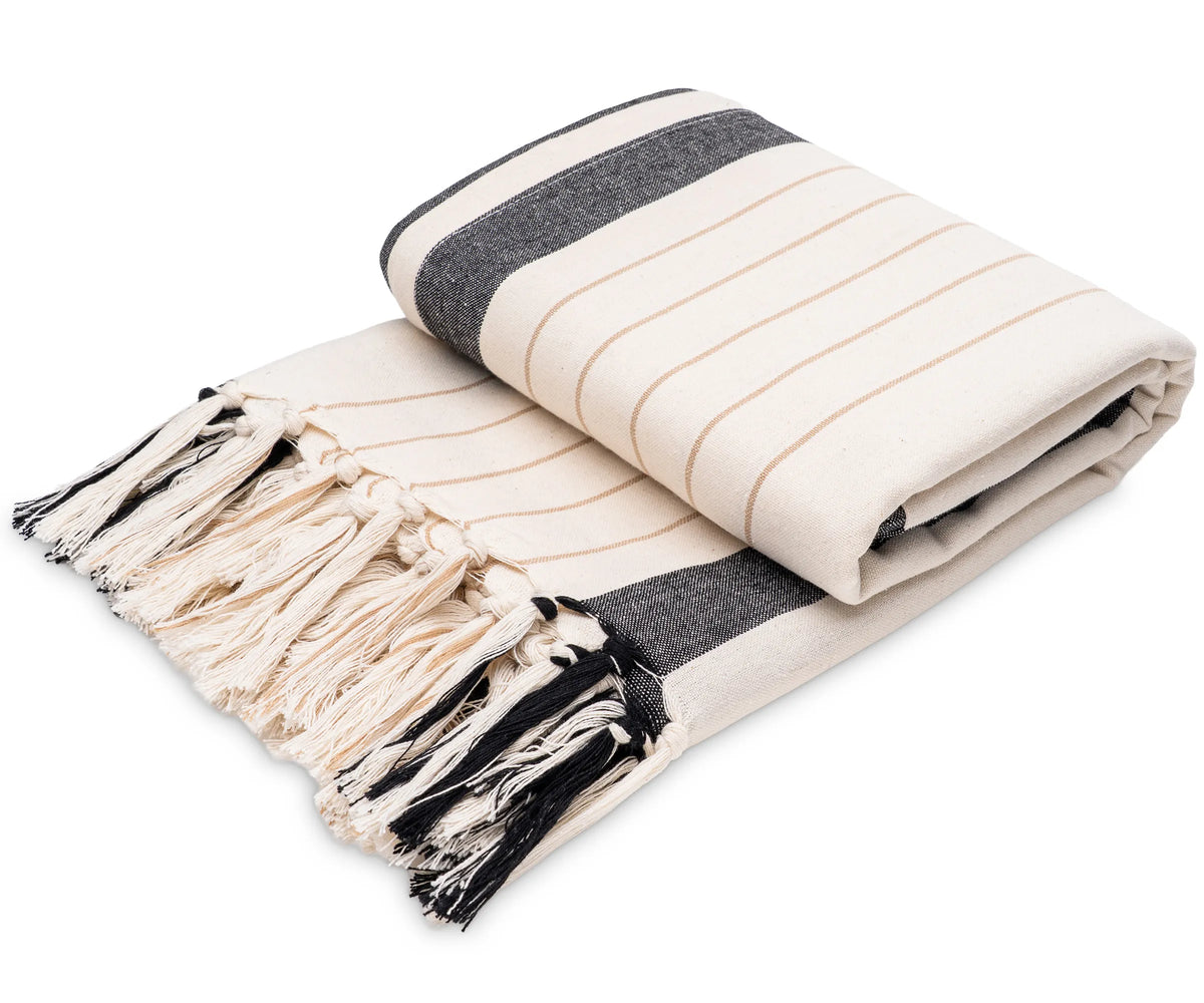 Black and white striped cotton throw draped over a sofa, offering a soft and breathable layer for everyday comfort