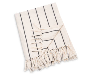 Soft cotton striped throw draped over a couch, offering cozy texture and simple elegance