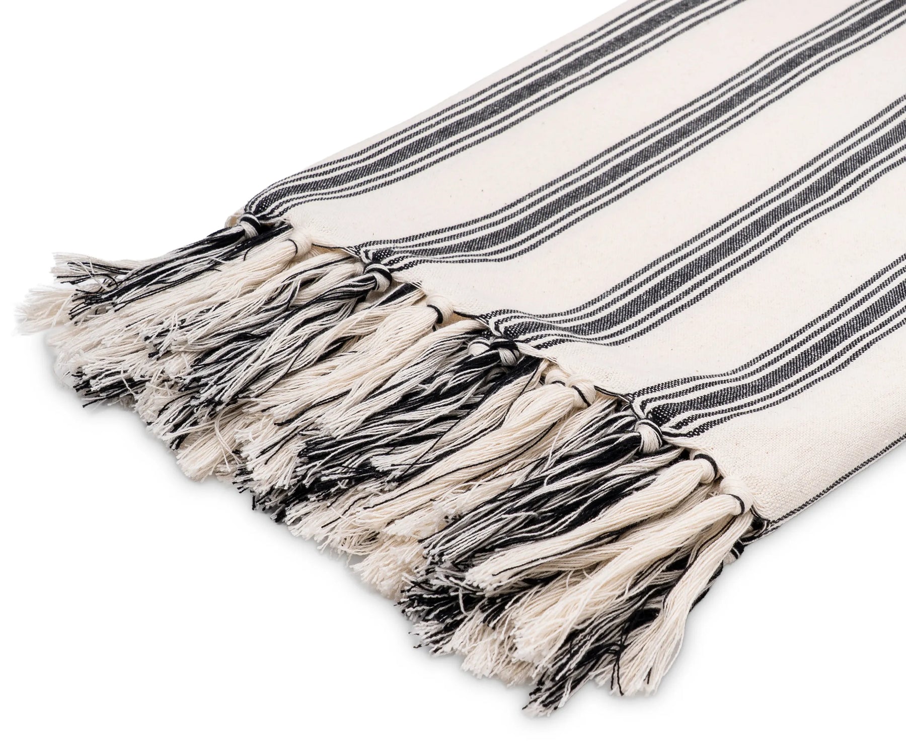 Lightweight black and white cotton throw draped over a couch for a cozy accent
