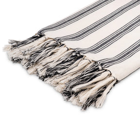 Lightweight black and white cotton throw draped over a couch for a cozy accent