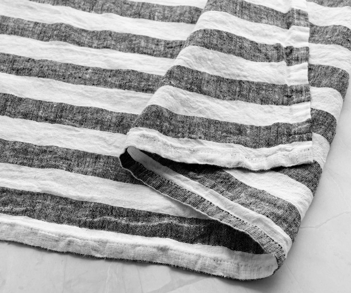 Black and white striped linen kitchen towel with soft textured fabric close-up