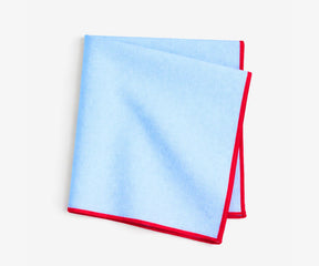 Embroidered blue cotton napkins featuring red merrow stitched edges for stylish dining and entertaining