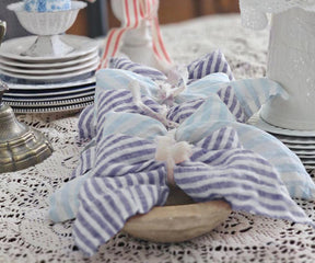 Blue pinstripe linen napkins complementing rustic wedding décor with relaxed sophistication and texture