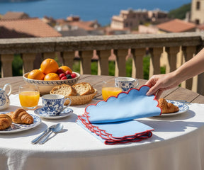 Blue and red scalloped napkin with decorative edge detailing for stylish table settings.