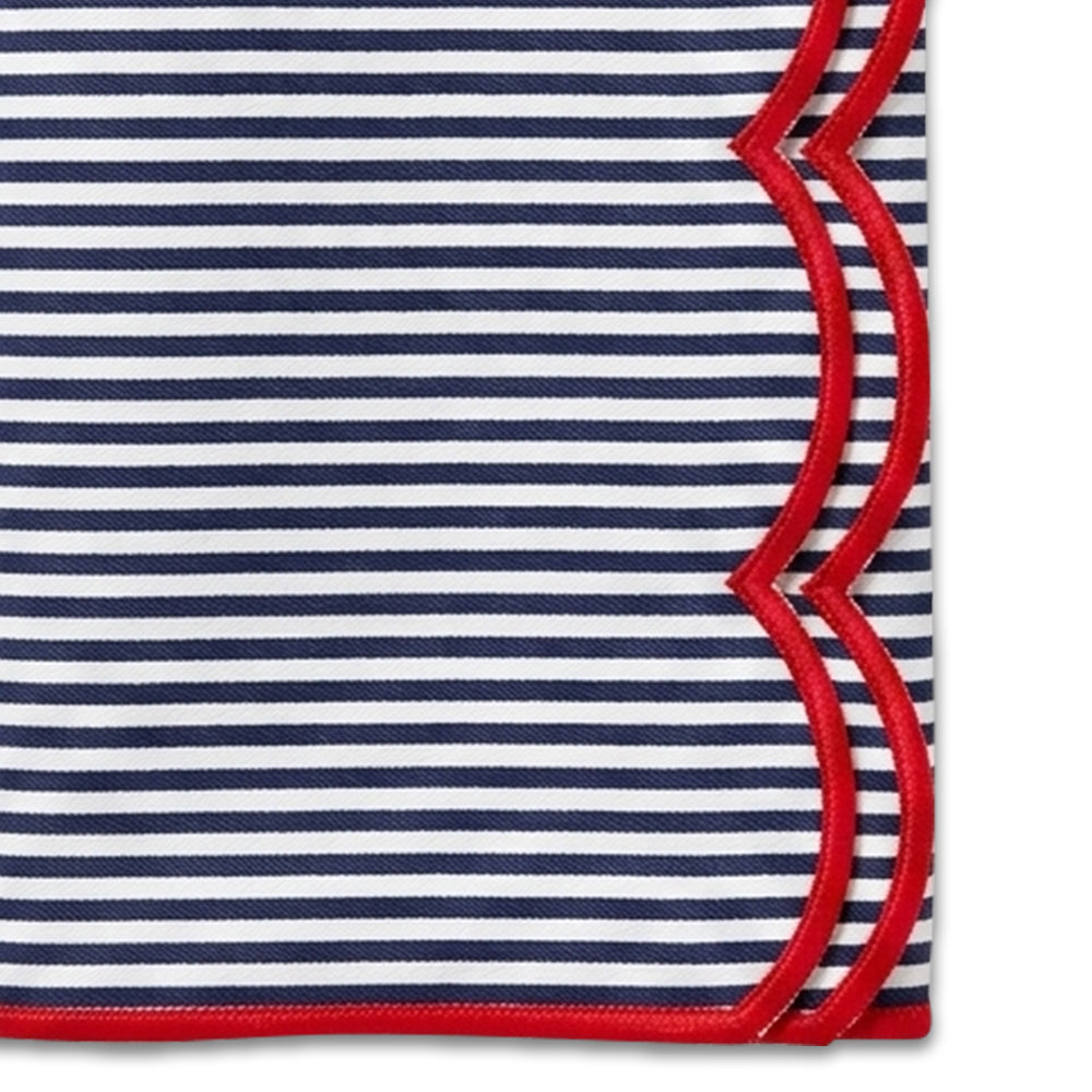 Cloth napkin featuring navy and white vertical stripes accented by a red scalloped border.