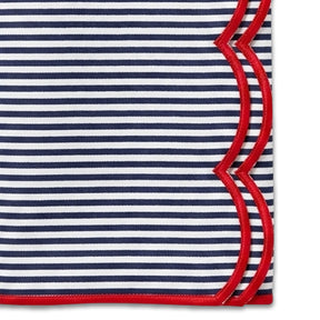 Cloth napkin featuring navy and white vertical stripes accented by a red scalloped border.