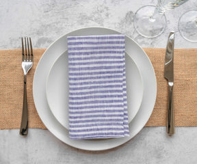 Blue and white pinstripe linen napkins arranged on reception tables for classic wedding décor inspiration