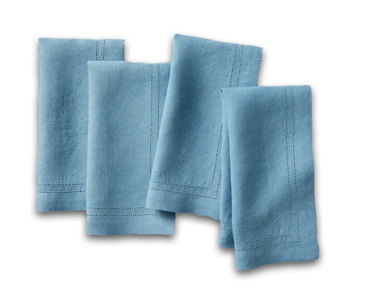 Blue linen hemstitch dinner napkins neatly folded on a dining table