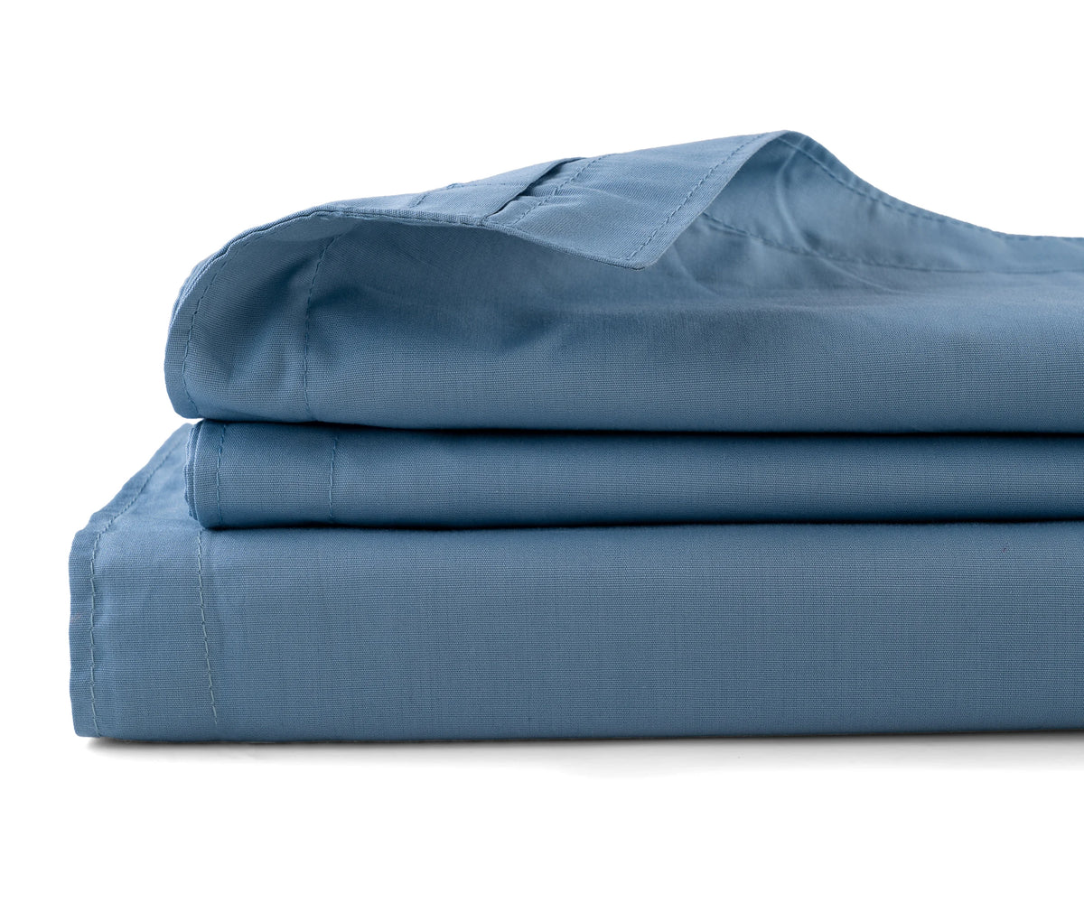 Folded light blue cotton flat sheet highlighting soft finish and elegant weave