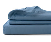 Folded light blue cotton flat sheet highlighting soft finish and elegant weave