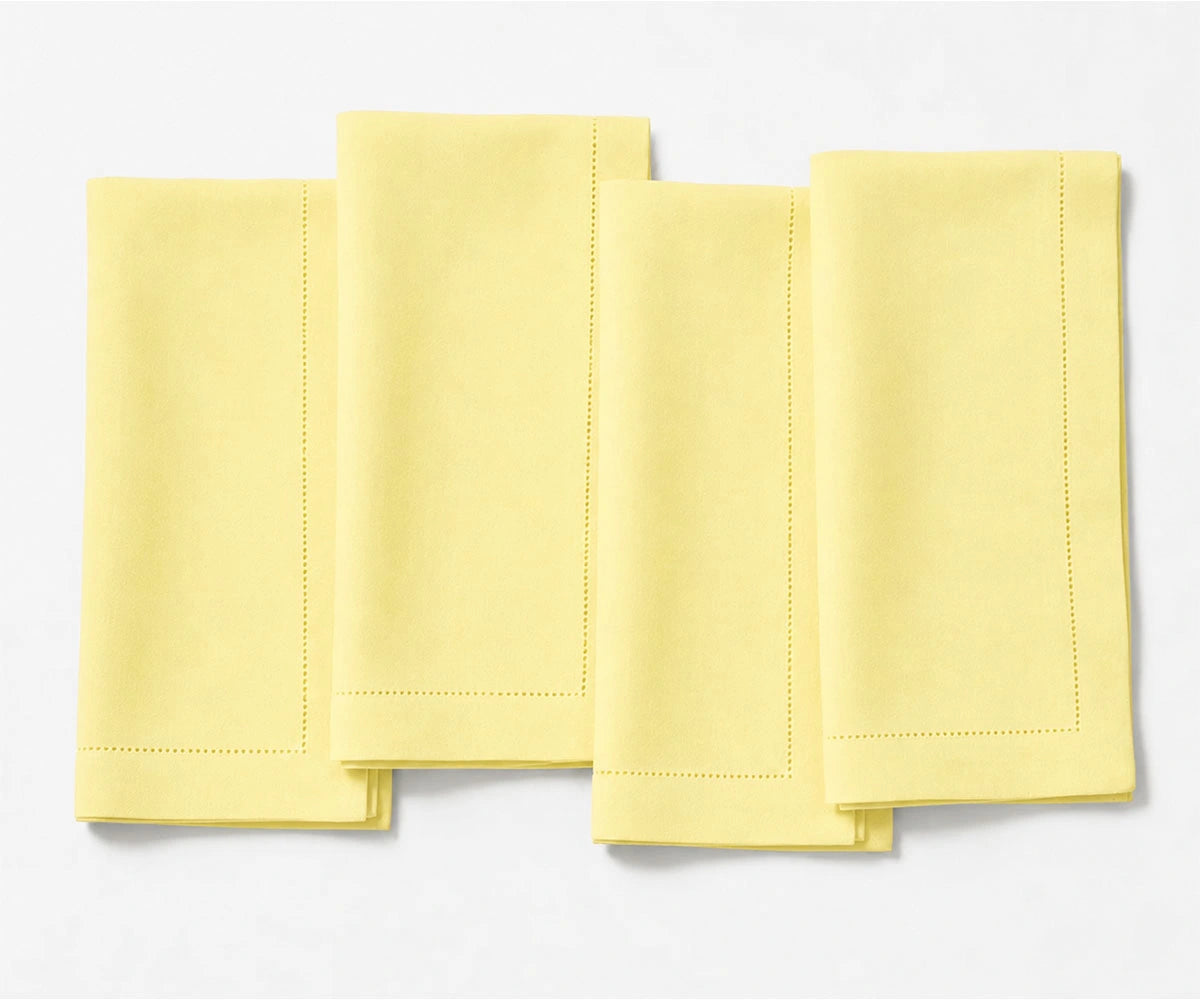 Durable butter yellow linen napkin set with refined hemstitch accents and soft washed finish