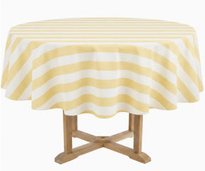 A round table covered with a butter yellow and white striped tablecloth, supported by a light wood pedestal table, isolated on a white background.
