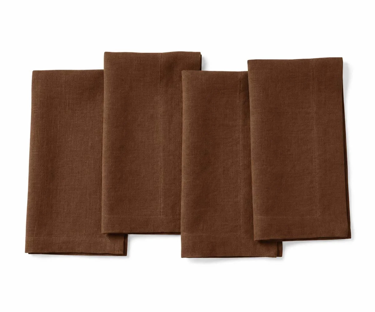 Set of four folded chocolate brown linen cloth dinner napkins for weddings and dining table settings