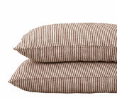 Chocolate brown striped linen pillowcases stacked on a white background