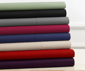 Stack of folded cotton bedsheets in assorted solid colors, best cotton sheets for summer
