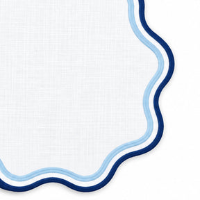 Blue round cloth placemat with decorative scalloped edge and contrasting trim, cotton table mat for dining room table settings.