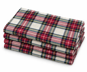 Stacked set of 4 cloth napkins with a classic red, green, and cream tartan plaid pattern