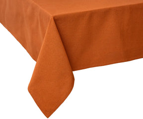Elegant dining table styled with a coral cotton tablecloth, neutral runners, and floral centerpieces, creating a warm and inviting tablescape for family dinners or weddings.
