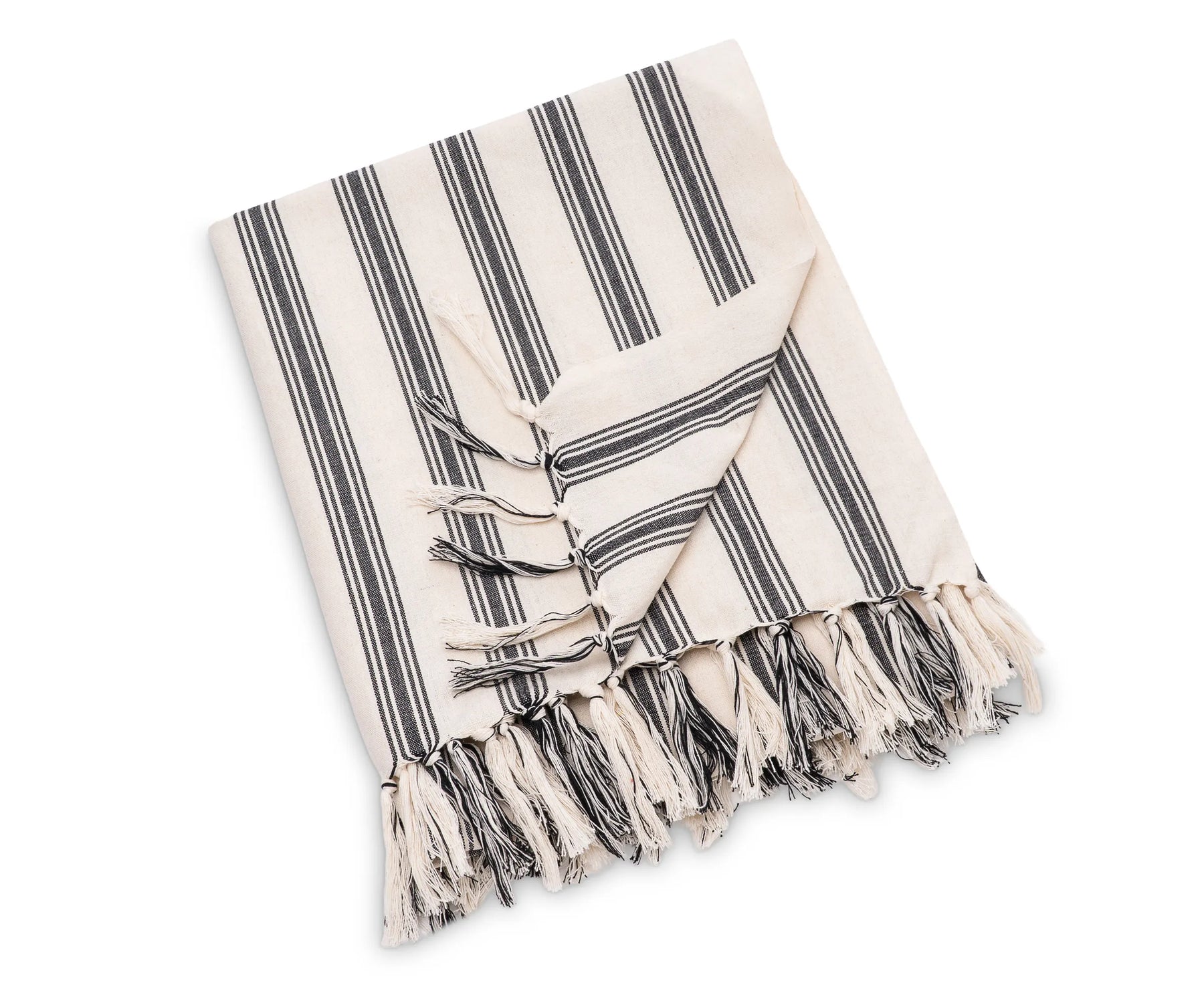Striped cotton throw blanket used as a decorative layer on a bed or seating area