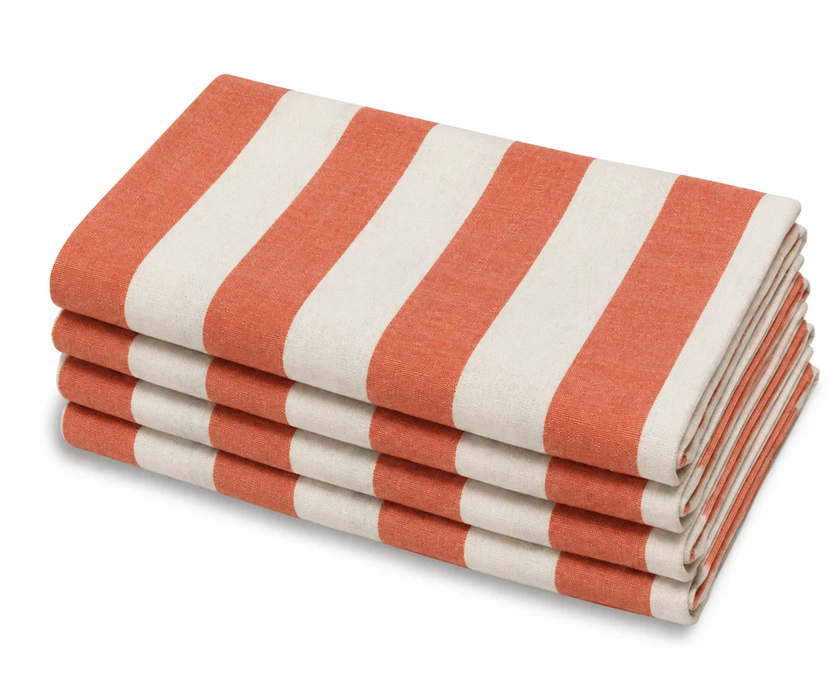 A stack of  orange and off-white striped cotton cabana dinner napkins.