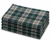 Green and white plaid cotton napkins set on a dining table with rustic dinnerware and seasonal centerpiece