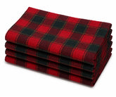 Red black and gold plaid cotton napkins set on a dining table with rustic dinnerware and seasonal centerpiece