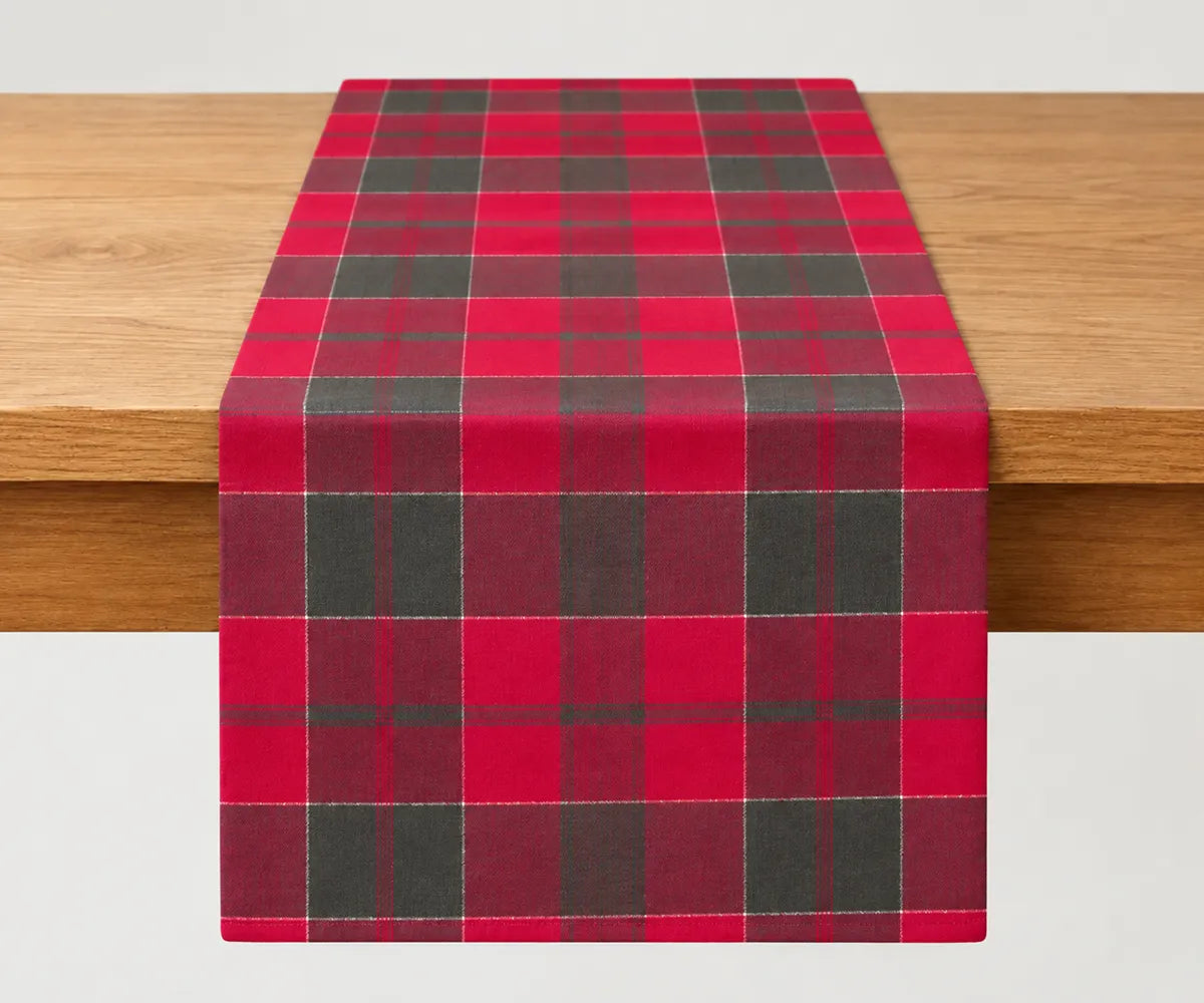 Red and green tartan plaid cotton table runner displayed on a dining table for Christmas and holiday table decor