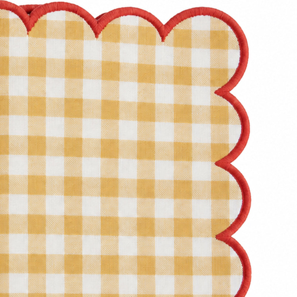 Close-up of yellow and white gingham cotton dinner napkin with dark green scalloped embroidered edge.