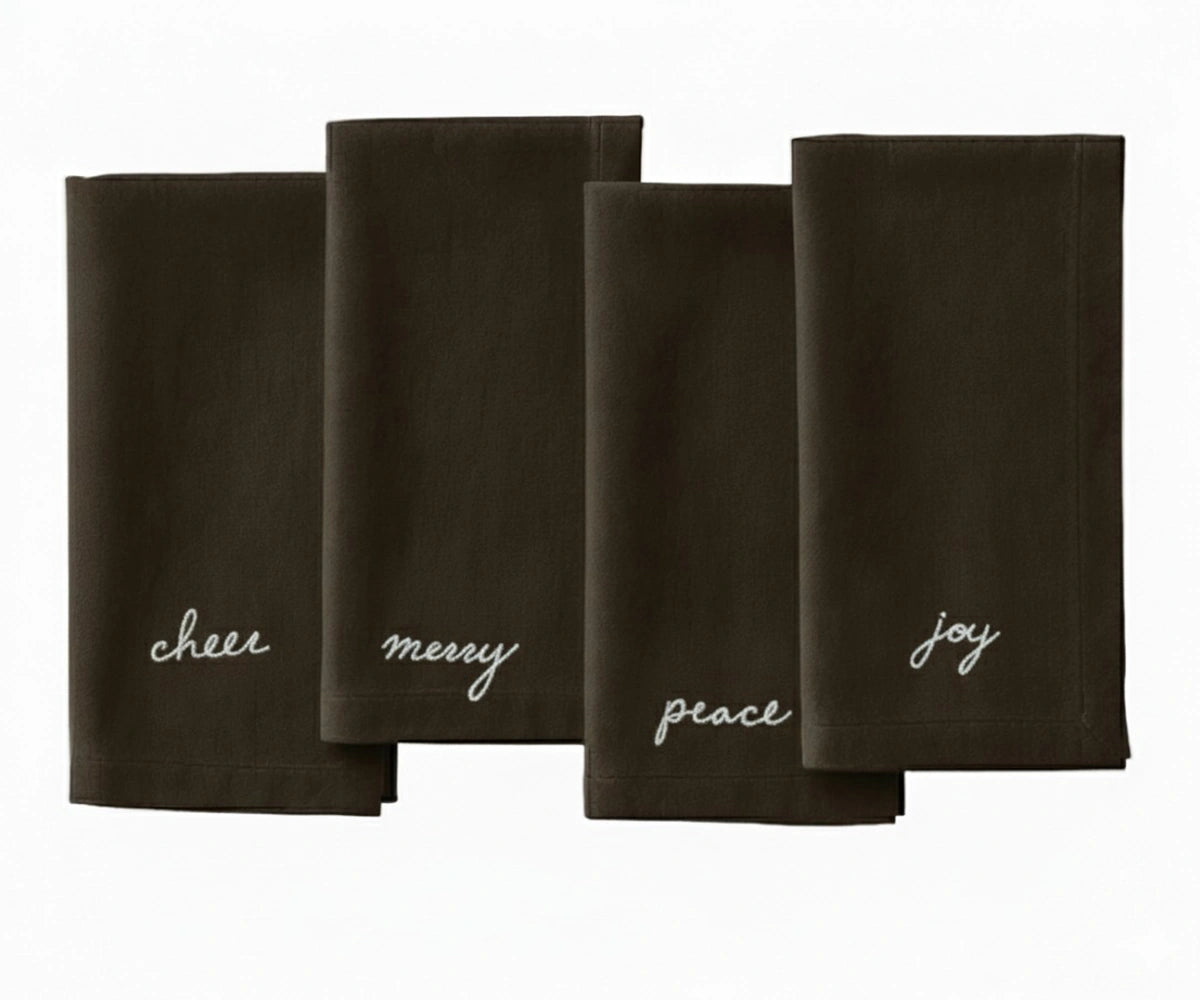 Brown Christmas embroidered napkin with white stitched festive sentiments — Peace, Joy, Merry, and Cheer.