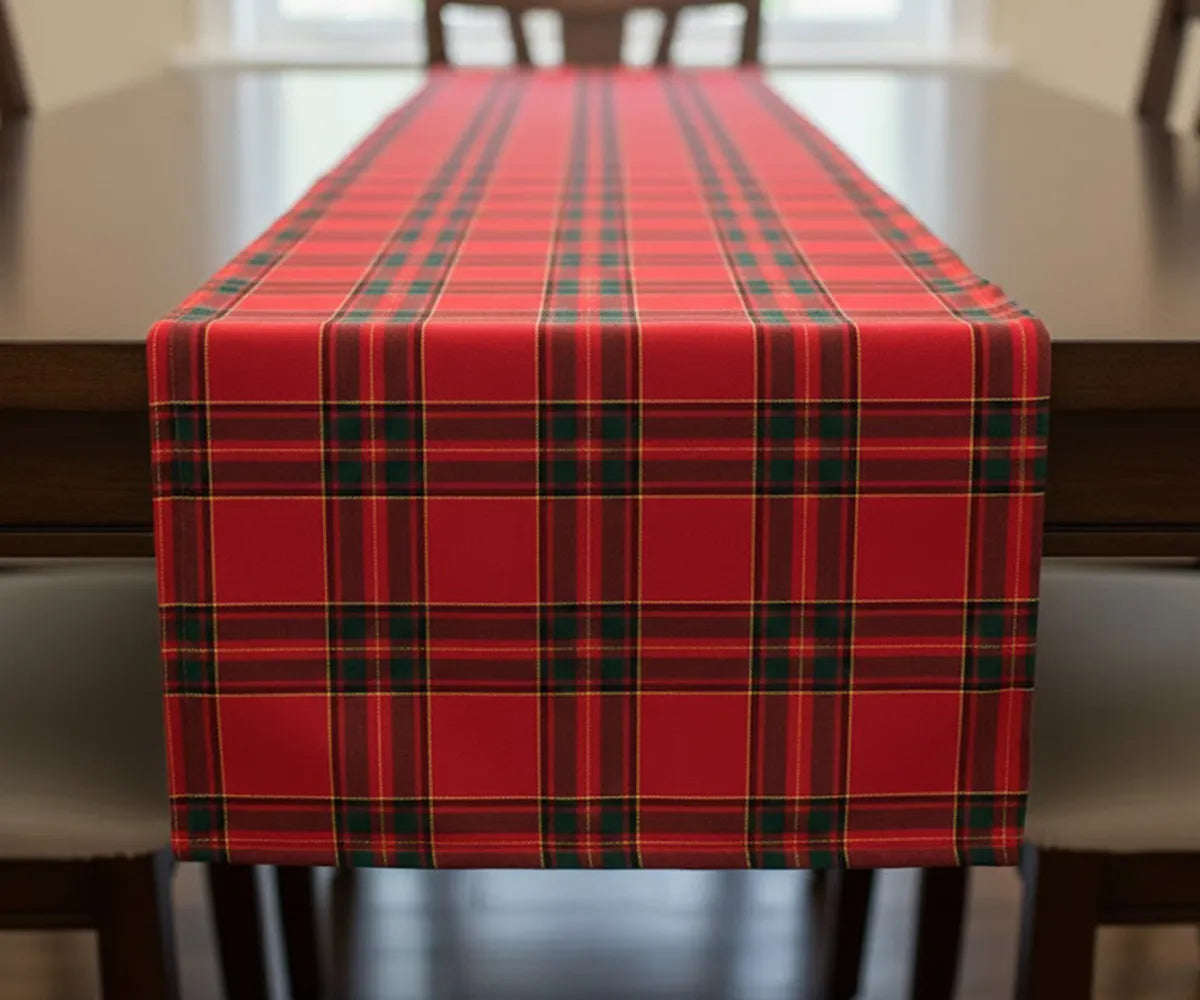 Red, black, and yellow tartan plaid cotton table runner laid across a table, adding classic Christmas charm and festive holiday warmth.