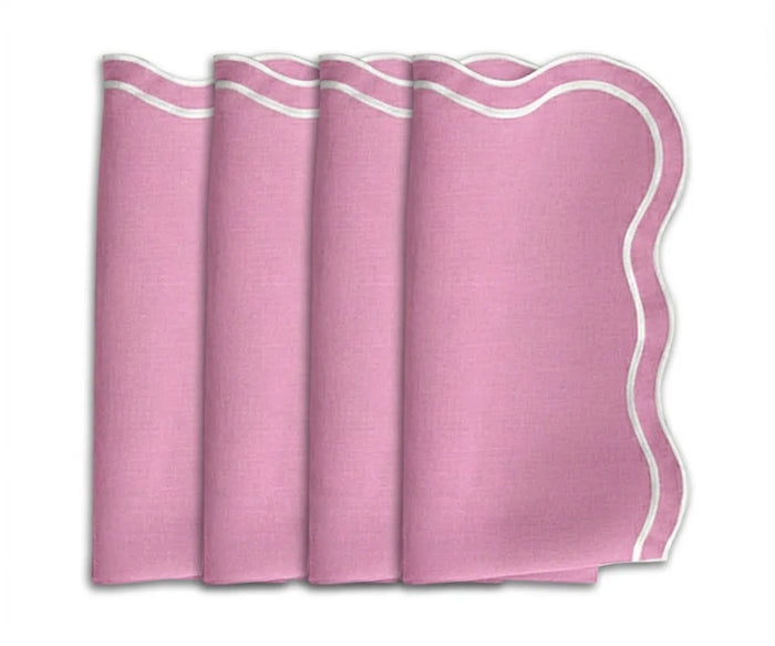 A set of pink cloth napkins with scalloped embroidered borders, neatly folded and displayed.