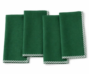 Four  green folded cloth napkins with white scalloped edges, arranged overlapping on a plain white background.