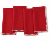 Four folded red cloth napkins with white scalloped embroidered borders, arranged overlapping on a white background.