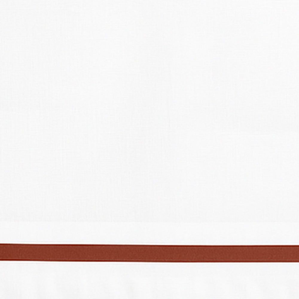 Close-up detail of white cotton pillowcase with a brown border line.