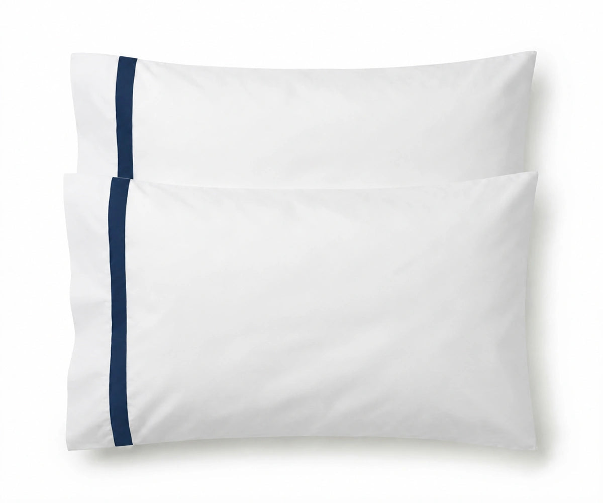 Pair of white cotton pillowcases featuring a single navy blue embroidered accent border line.
