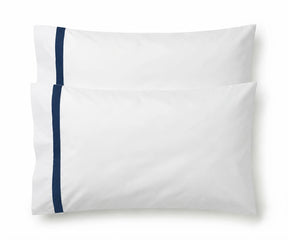 Pair of white cotton pillowcases featuring a single navy blue embroidered accent border line.
