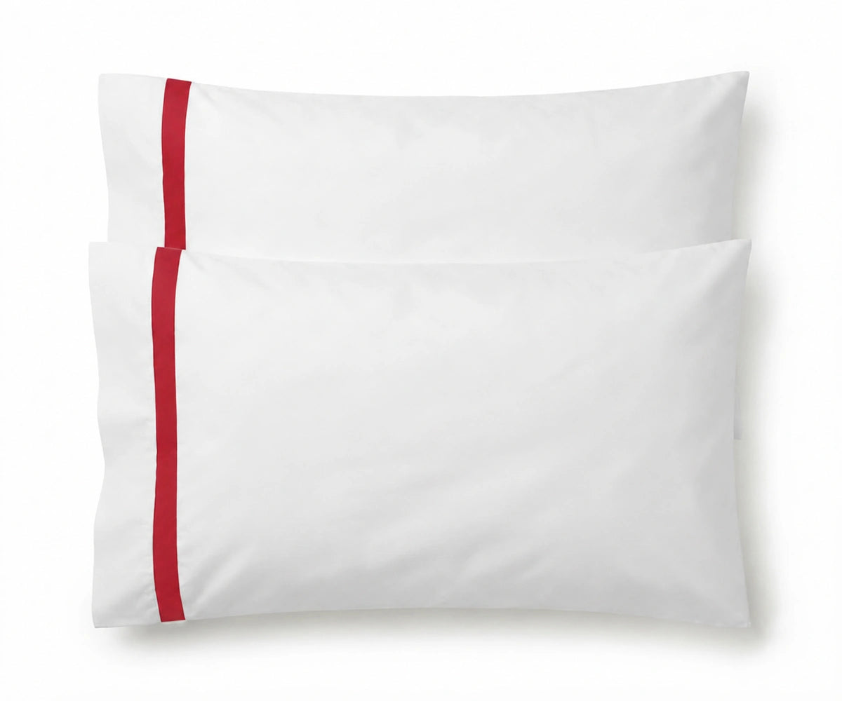 Pair of white cotton pillowcases featuring a single red embroidered accent border line.