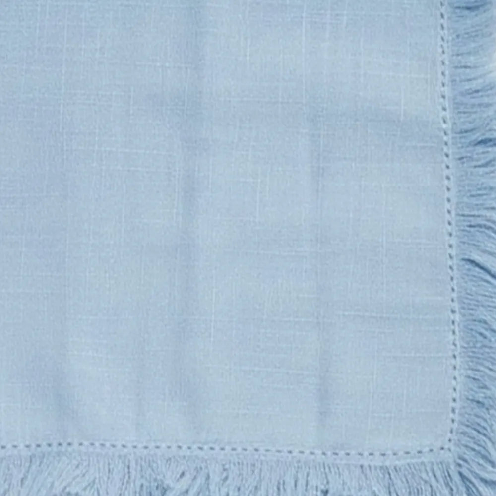 Set of blue fringed cotton napkins featuring stylish clothing fringe trim along the edges. Machine-washable and fade-resistant reusable table napkins designed for sustainable dining, perfect for pairing with matching blue cotton tablecloths for a coordinated table decor.