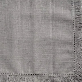 Elegant cotton table napkins with fringe borders, sustainable and stylish option for modern table decor.