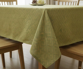 Green floral cotton tablecloth draped on wooden dining table