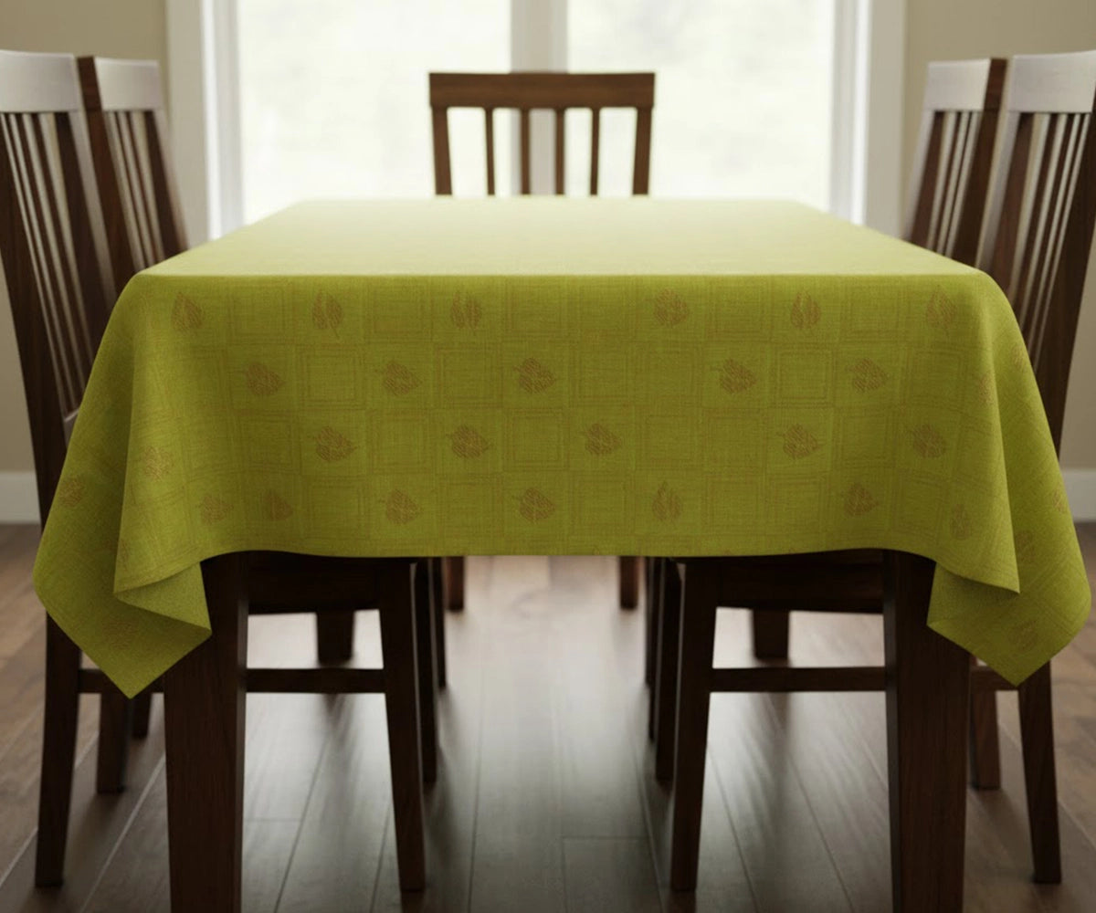 Green leaf printed cotton tablecloth draped on rectangular dining table