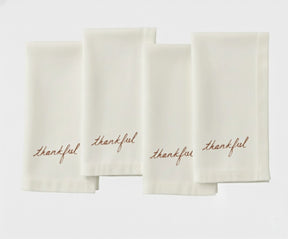 Ivory dinner napkin with decorative stitched detailing for timeless table décor.