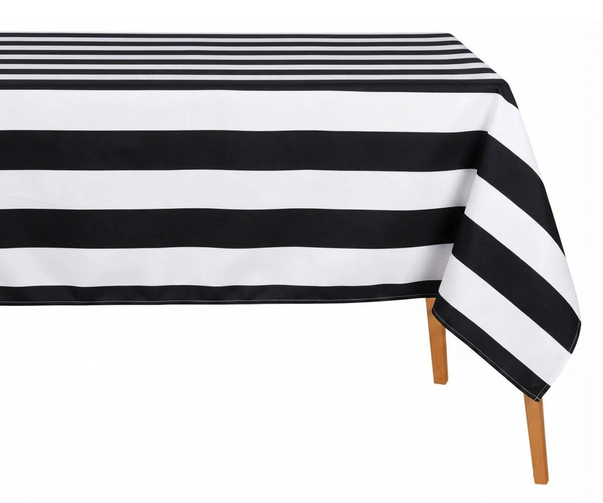 Black and white wide cabana striped cotton linen tablecloth with straight edges draped over a dining table.