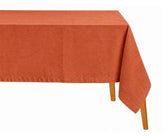Terracotta hemstitched rectangular tablecloth draped over a dining table