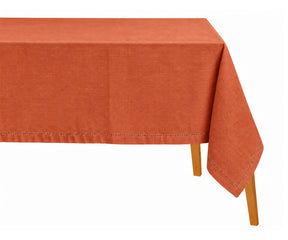 Terracotta hemstitched rectangular tablecloth draped over a dining table