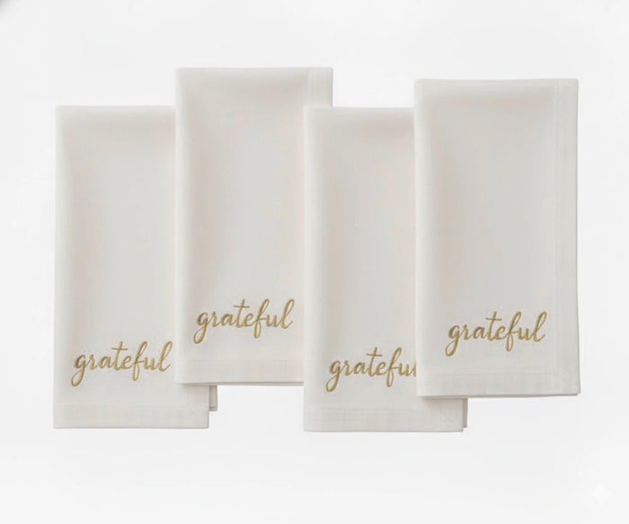 Ivory embroidered napkin showcasing “Grateful” in beige thread for elegant table décor.