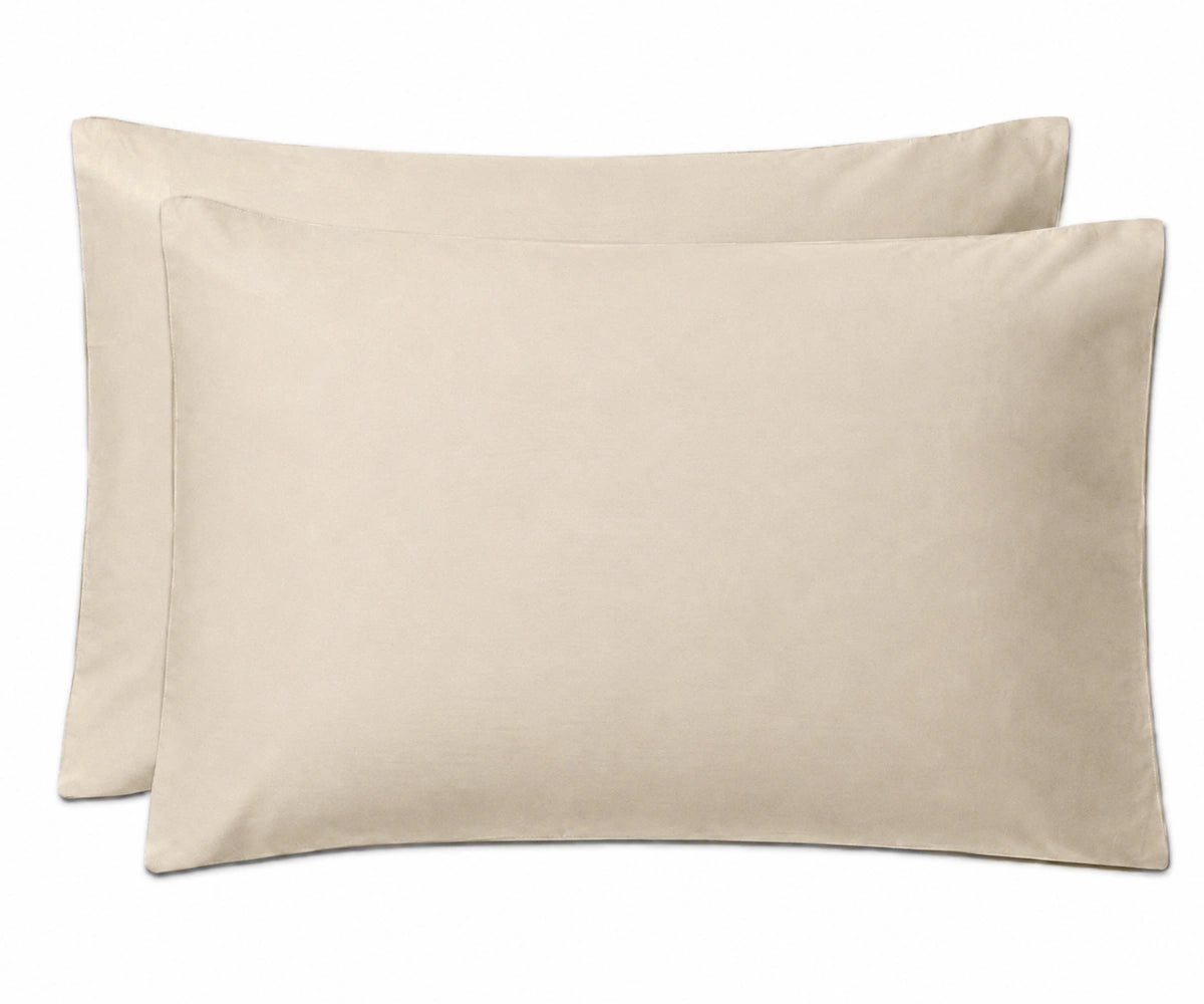 Two plain rectangular pillowcases in a light warm beige color, shown overlapping on a clean white background.