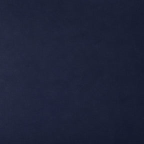 A close-up of a solid dark navy blue textured surface, likely fabric or leather.