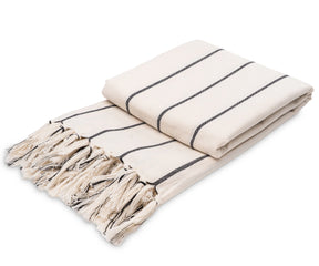 Modern black and white cotton throw blanket used as a decorative accent in a living space