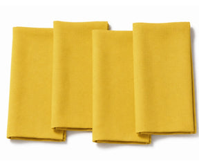 Set of four folded sunflower yellow cotton dinner napkins arranged on a white background.